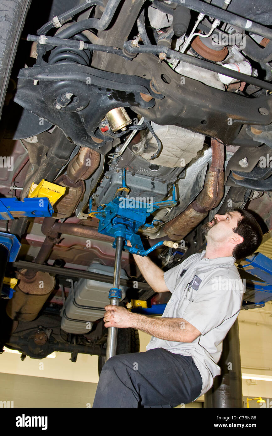 Mechanic setting up transmission jack Stock Photo - Alamy