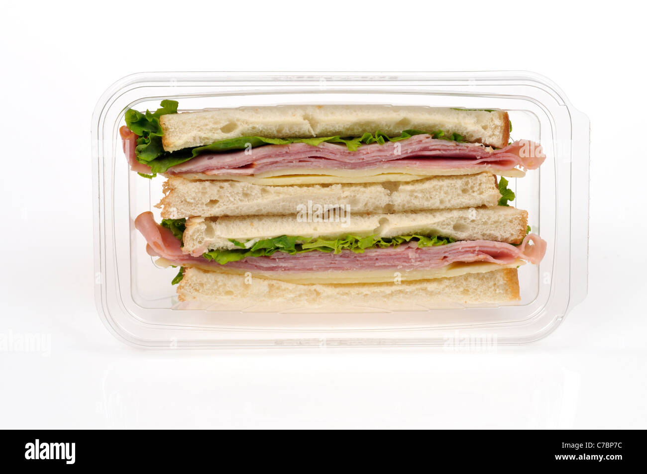 Ham salad with cheese takeaway sandwich on white bread in plastic packet container on white background, cutout. Stock Photo