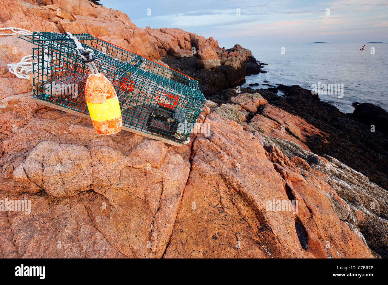 Lobster trap washed up on pink granite rocky shoreline, Mount Desert Island, Acadia National Park, near Bar Harbor, Maine, USA Stock Photo