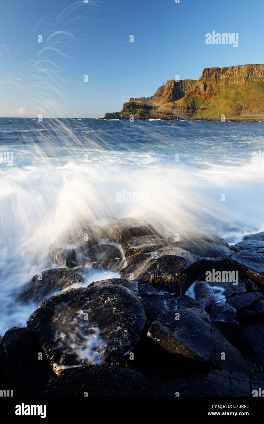 Waves splashing over basalt columns near sunset, Giant's Causeway, County Antrim, Northern Ireland, United Kingdon Stock Photo