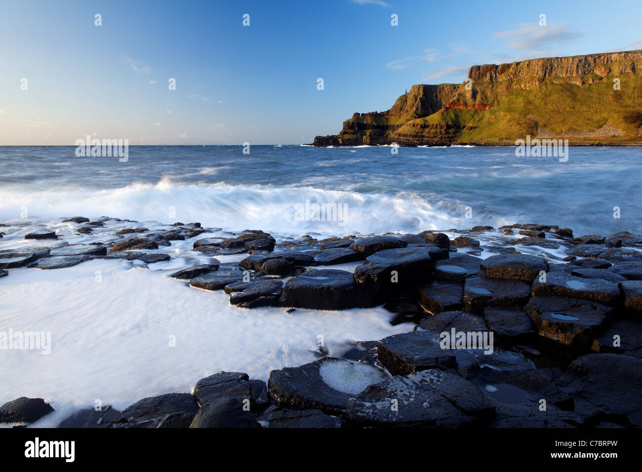 Waves splashing over basalt columns near sunset, Giant's Causeway, County Antrim, Northern Ireland, United Kingdon Stock Photo