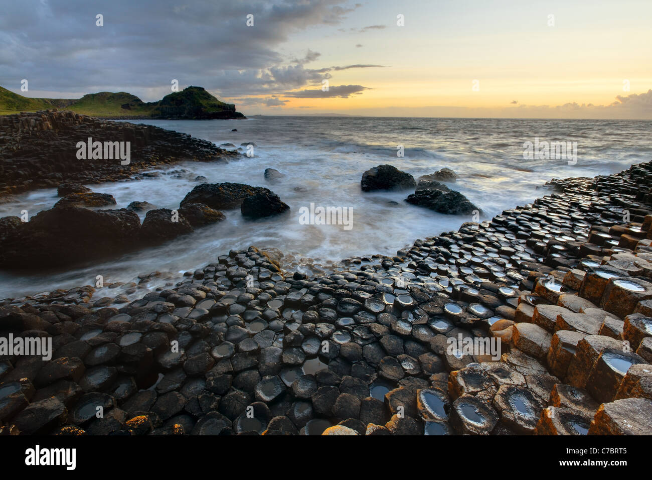 Waves splashing over basalt columns near sunset, Giant's Causeway ...