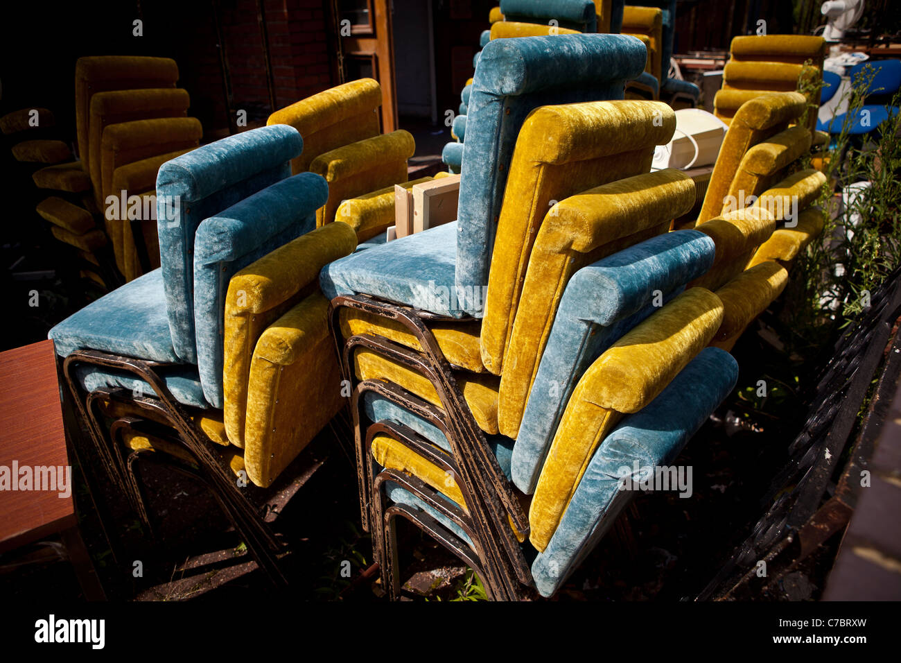 Stacks of crushed velvet blue and green coloured chairs. Stock Photo