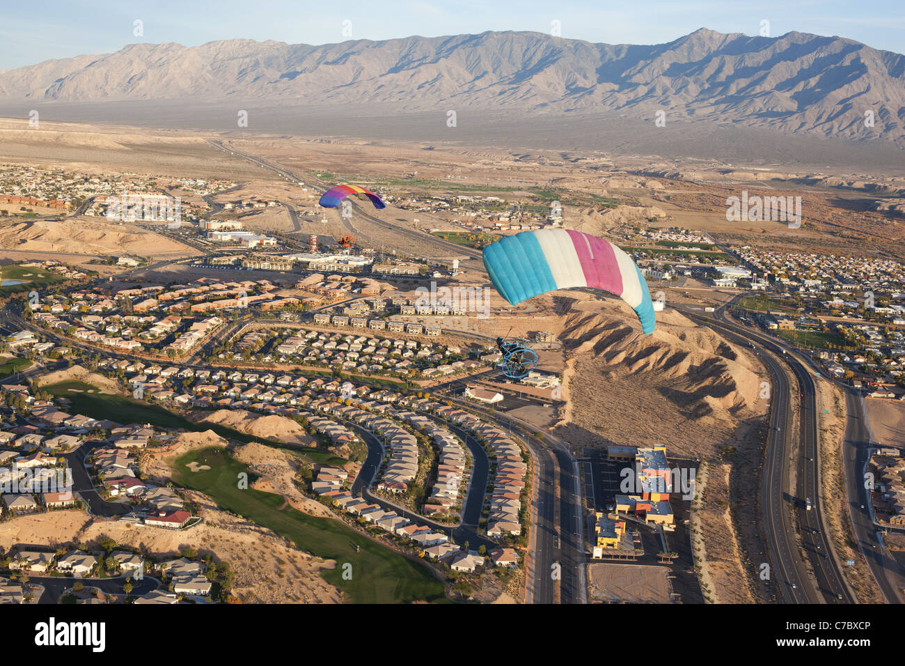 AIR-TO-AIR VIEW. Two powered parachutes cruising above the desert town of Mesquite. Mojave Desert, Clark County, Nevada, USA. Stock Photo
