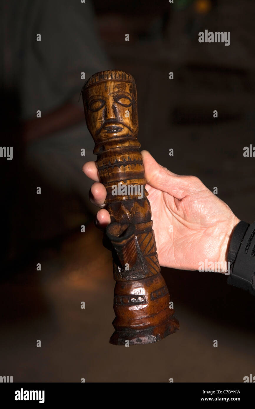 India, Nagaland, Longwa, Konyak Naga village western visitor’s hand holding old ivory opium pipe Stock Photo