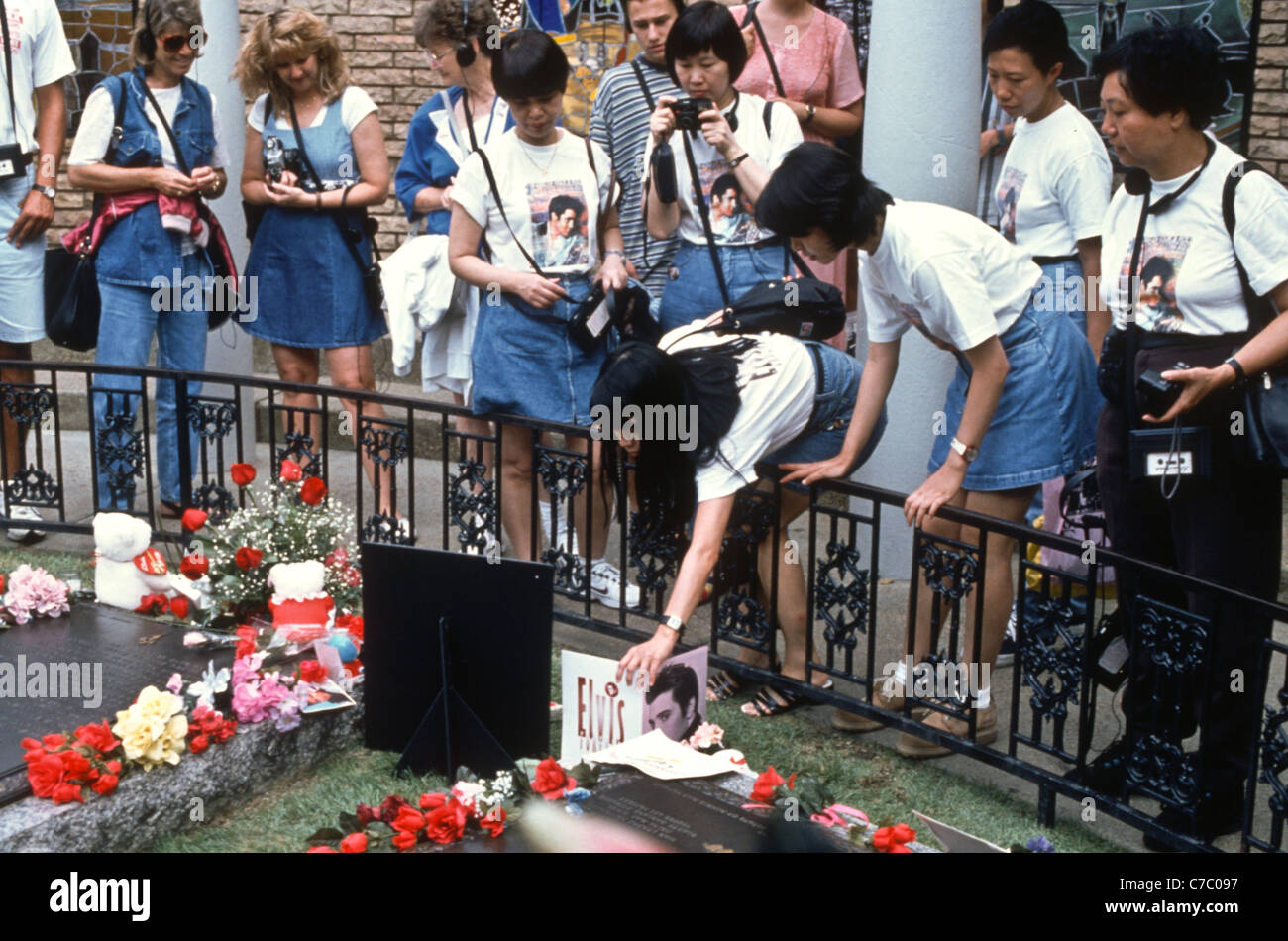 Elvis Presley fans place flowers and cards on his grave on the