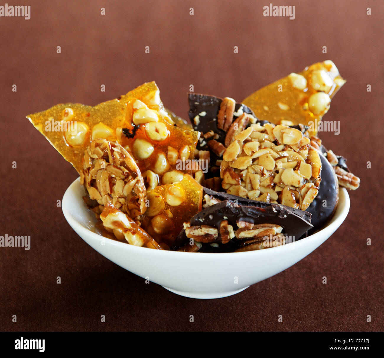 Hazelnut brittle, almond Florentines and chocolate pecan bark in a bowl, by pastry chef Laurie Pfalzer, Pastry Craft Stock Photo