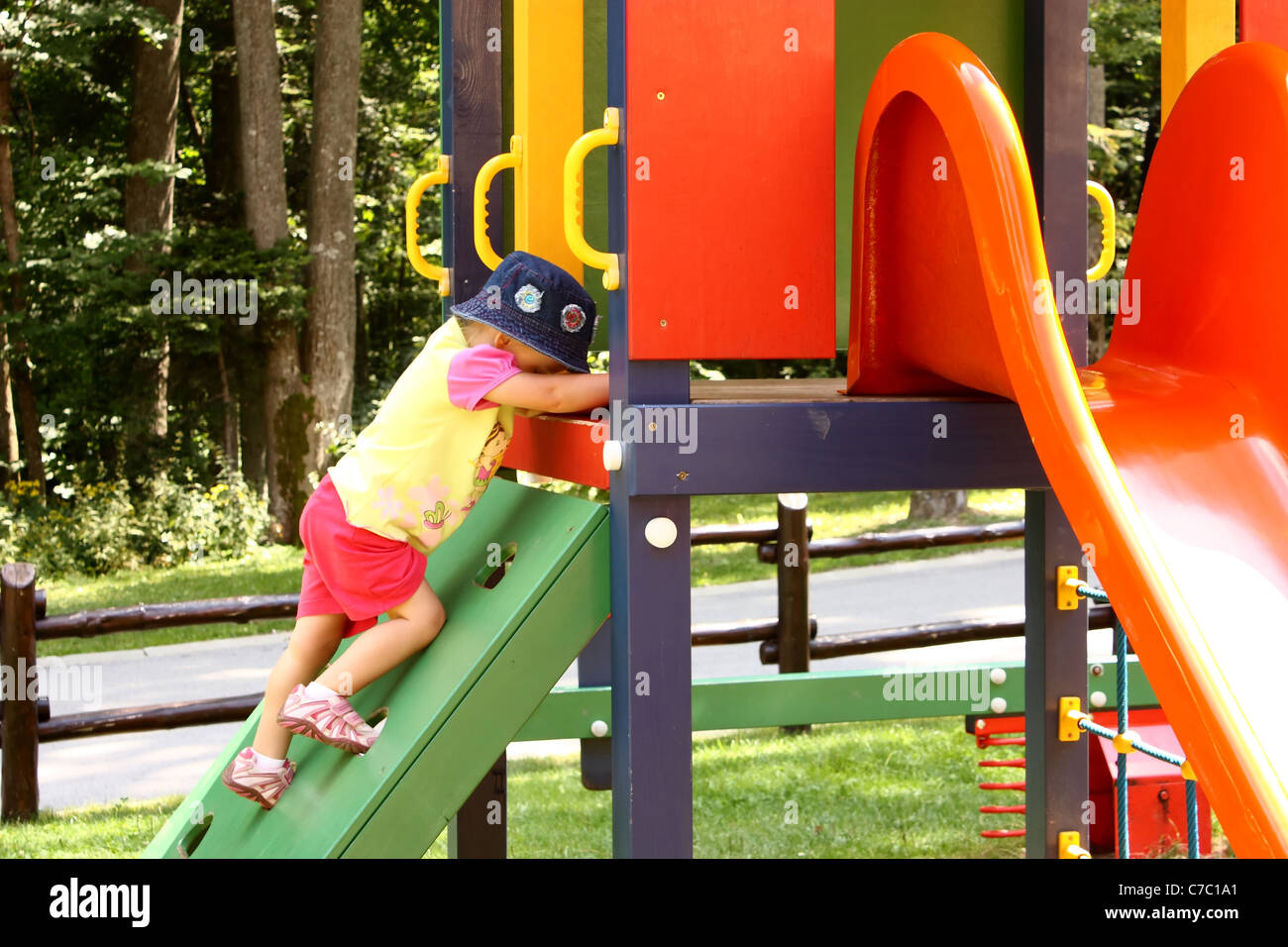Little girl playing on the colorful slide in playground Stock Photo - Alamy