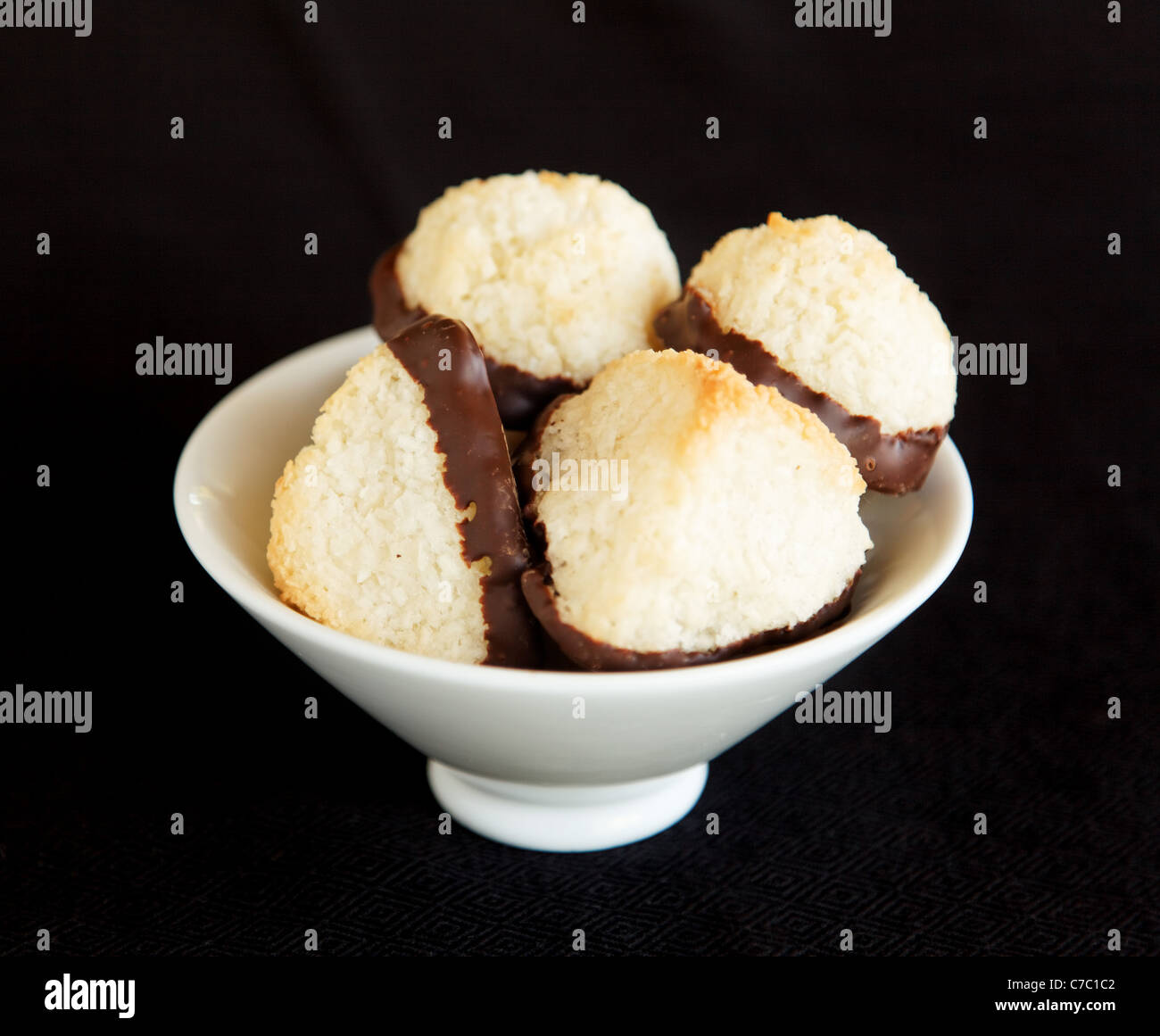 Coconut macaroons dipped in chocolate in white bowl, by pastry chef Laurie Pfalzer, Pastry Craft Stock Photo