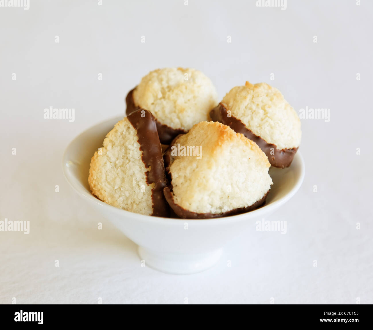 Coconut macaroons dipped in chocolate in white bowl, by pastry chef Laurie Pfalzer, Pastry Craft Stock Photo