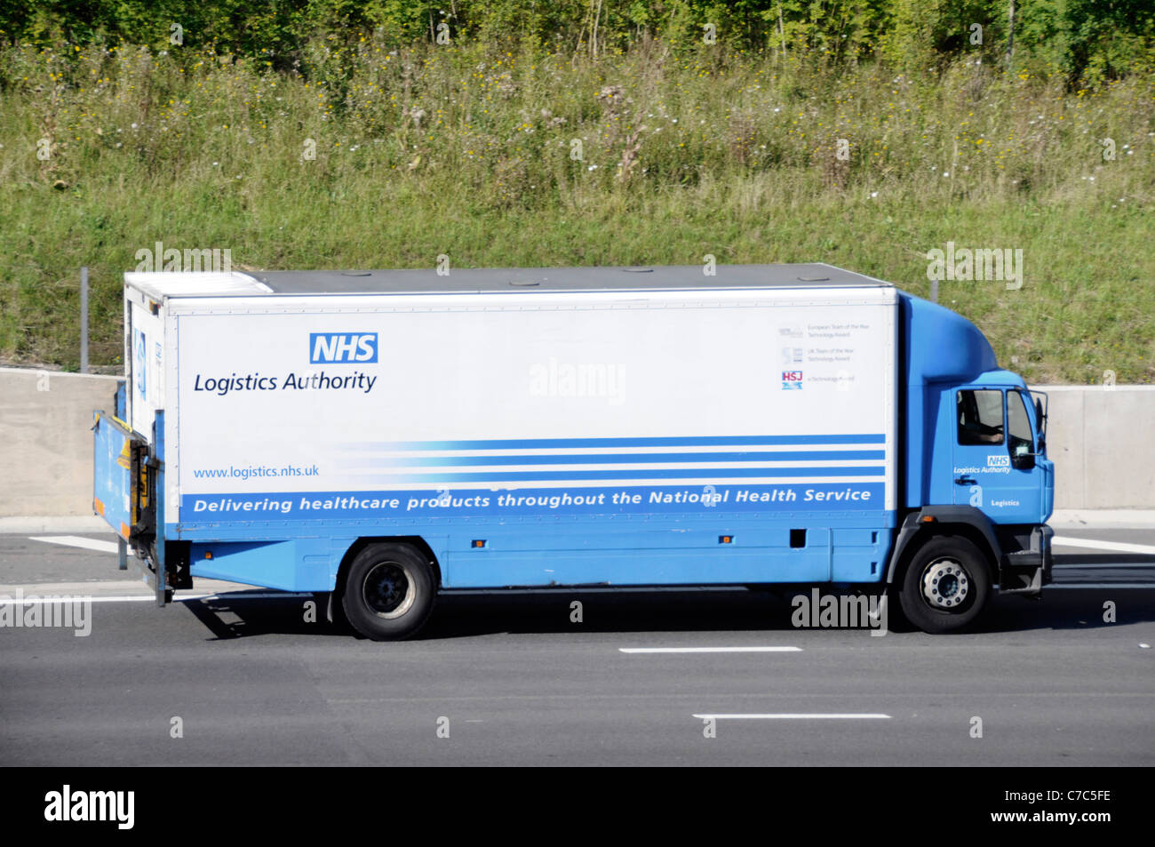 Logistics Authority NHS supply chain hgv delivery lorry truck delivering medical healthcare value to national health service driving along UK motorway Stock Photo
