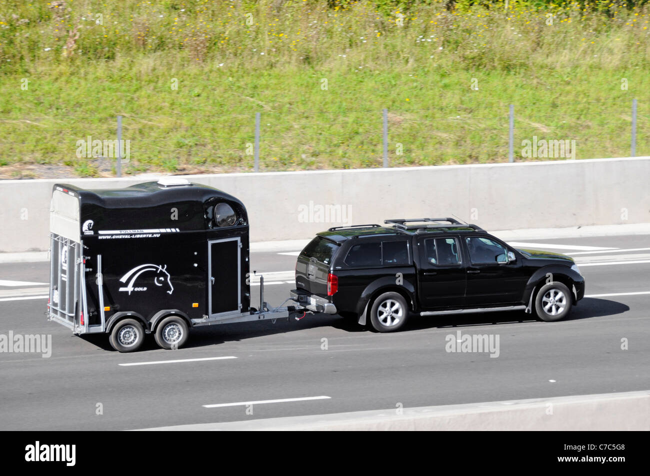 Side view of black car towing black Hungarian Cheval Liberte business
