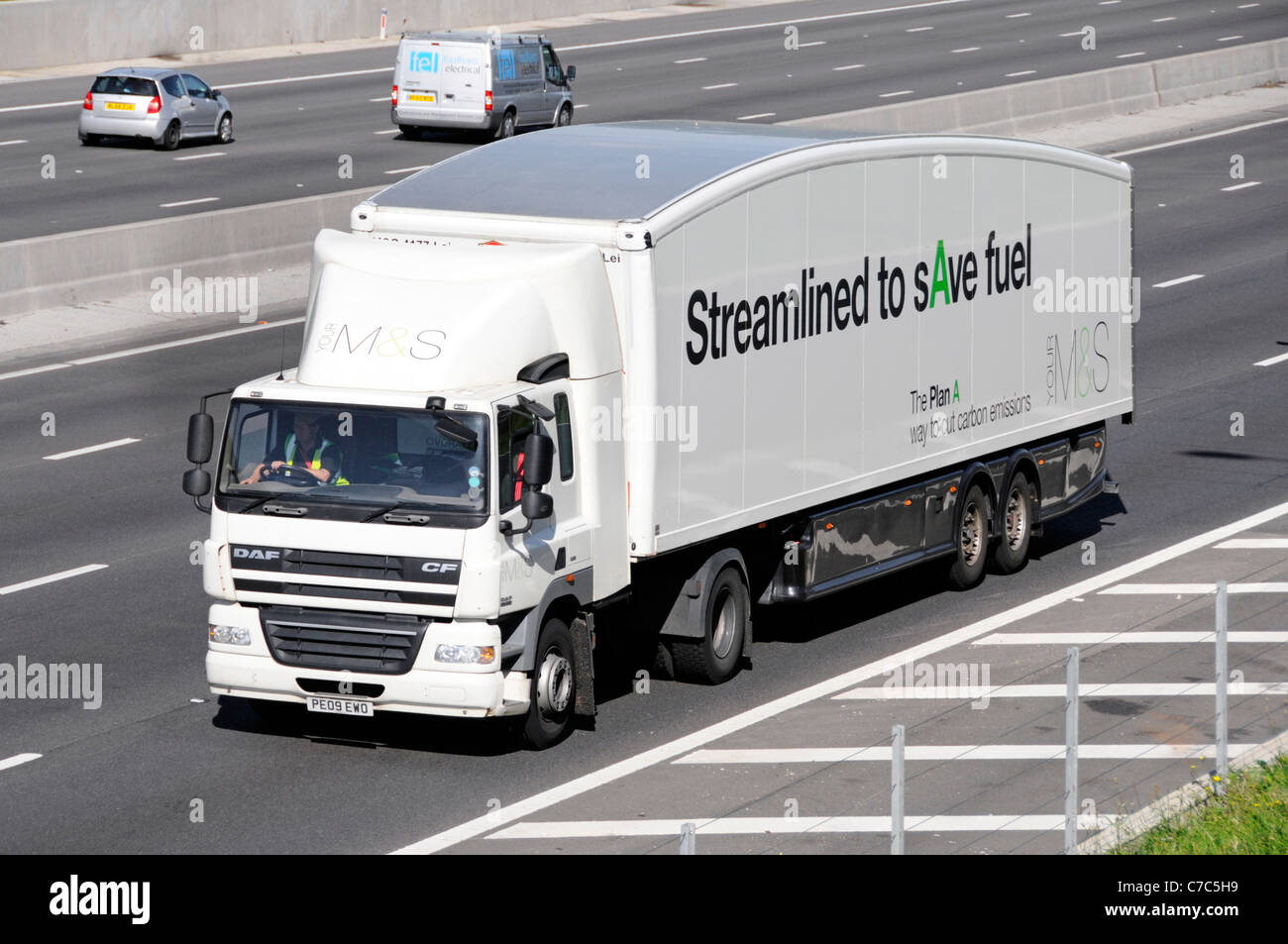 Streamlined M&S articulated store delivery supply chain DAF CF hgv lorry truck and trailer with fuel saving slogan M25 motorway road Essex England UK Stock Photo