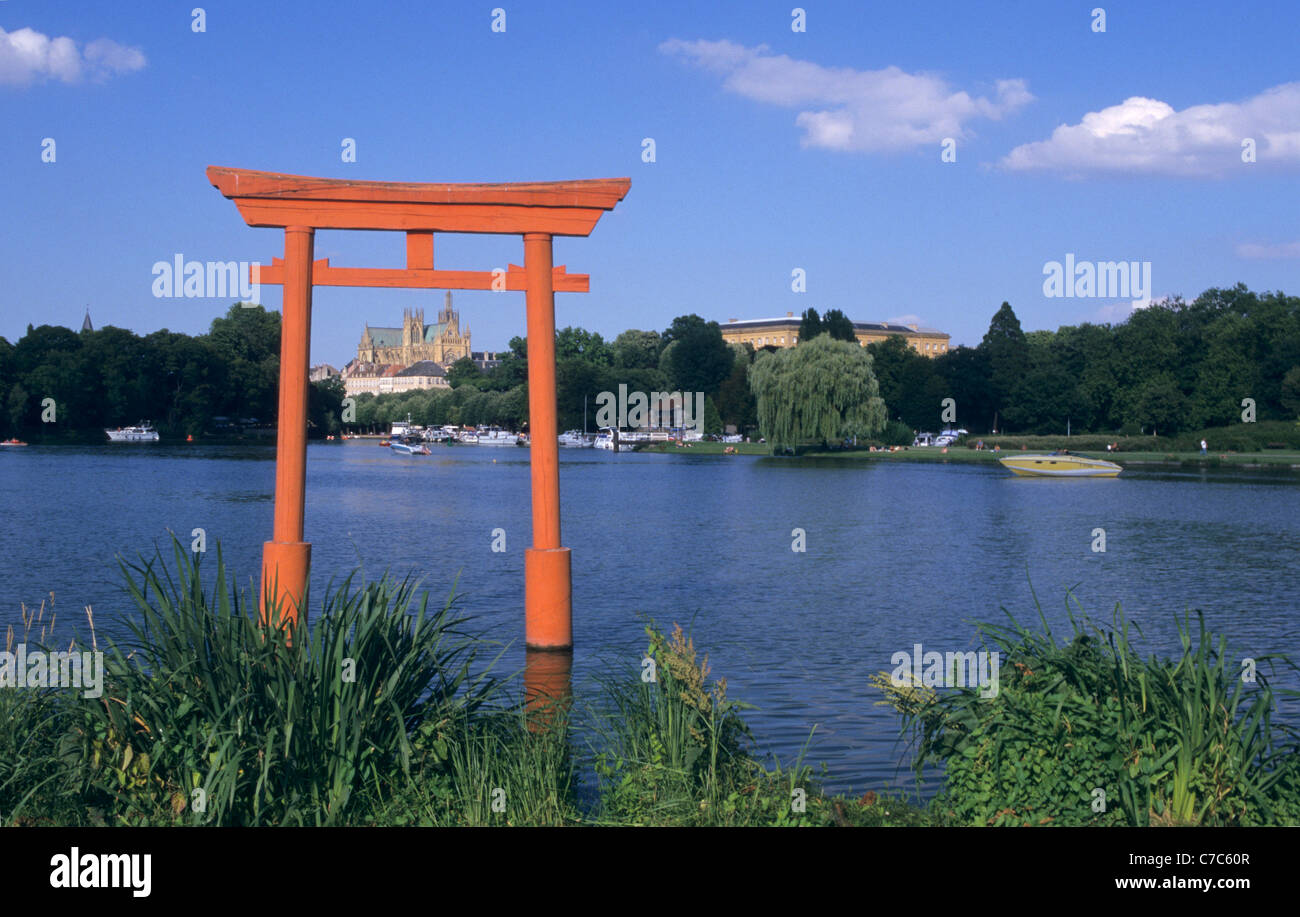 Japanese torii gate on City lake (plan d'eau du Saulcy) with cathedral St Etienne, Metz town, Moselle, Lorraine region, France Stock Photo