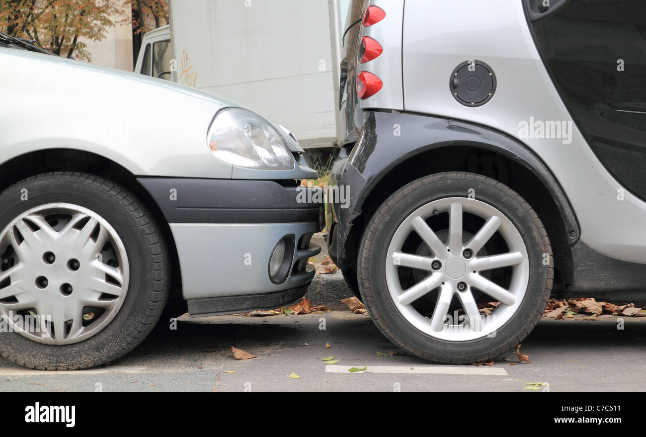 Bumper To Bumper Two cars parallel parked on a street less than an