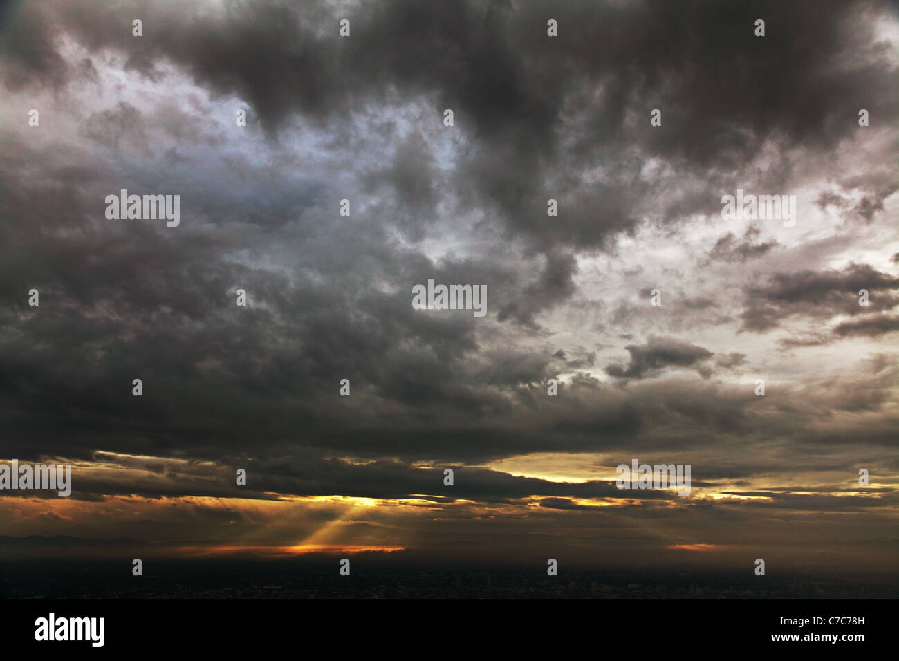 Dramatic sky of heavy gray clouds and sunbeams Stock Photo