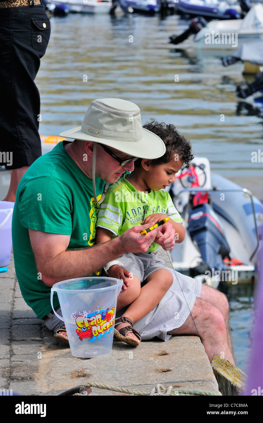 Father and son fishing for crabs off Victoria Quay Town Devon