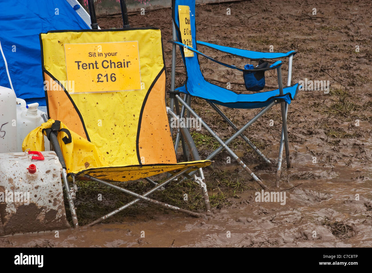Thick mud at Glastonbury Festival with mud coated camping equipment for