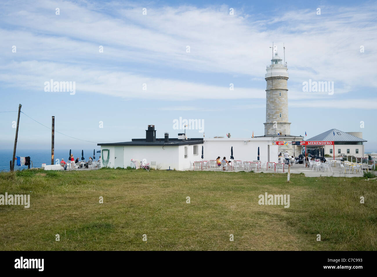 Some people are having a drink  in a Restaurant next to the Cabo Mayor lighthouse in Santander in the Cantabric Coast Stock Photo