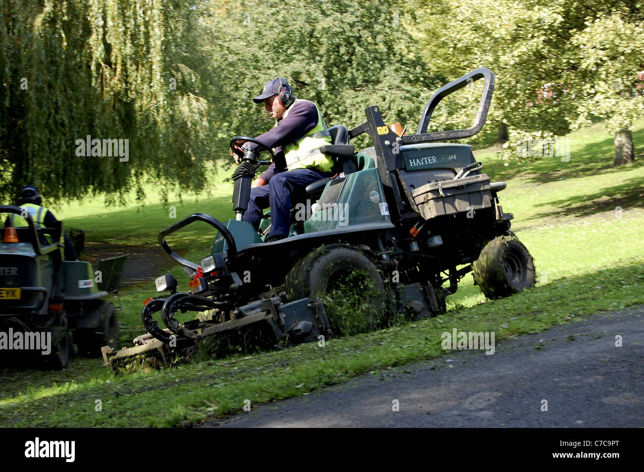 Council motorised grass cutter in park Stock Photo