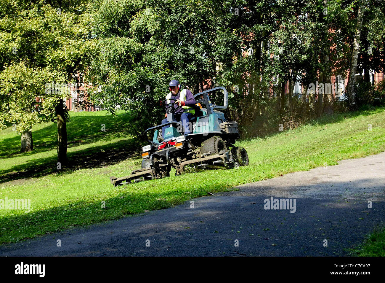Council motorised grass cutter in park Stock Photo Alamy