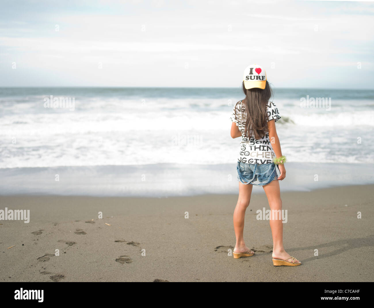 I love surf - young girl on the beach looking at the surf Stock Photo