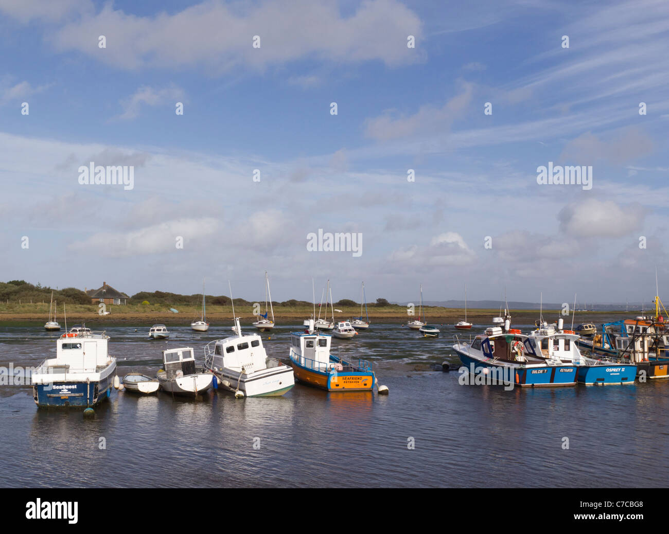 Tranquil view of Moored Fishing Boats and Yachts in tidal estuary at Hurst Castle Spit near Keyhaven Yacht Club, Milford On Sea Stock Photo
