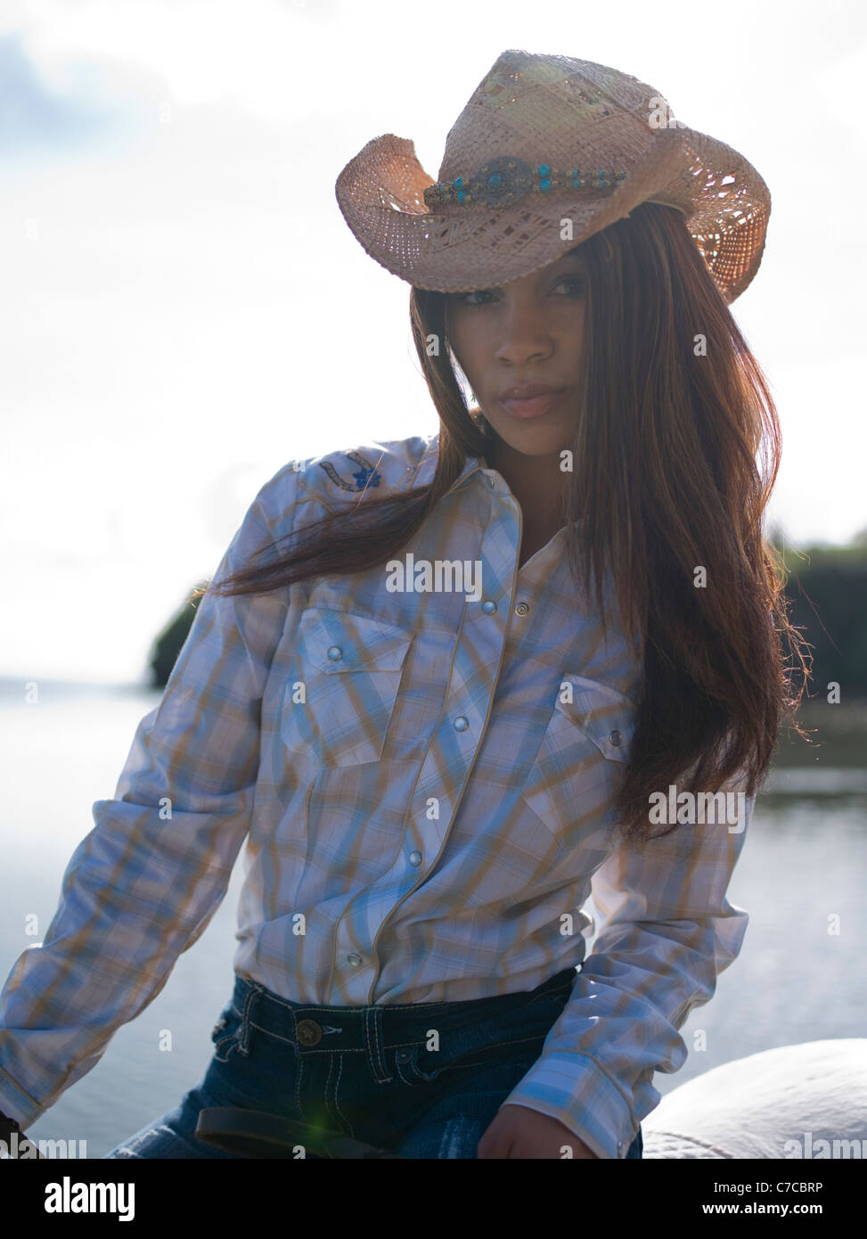 Cowgirl on horseback on beach Stock Photo