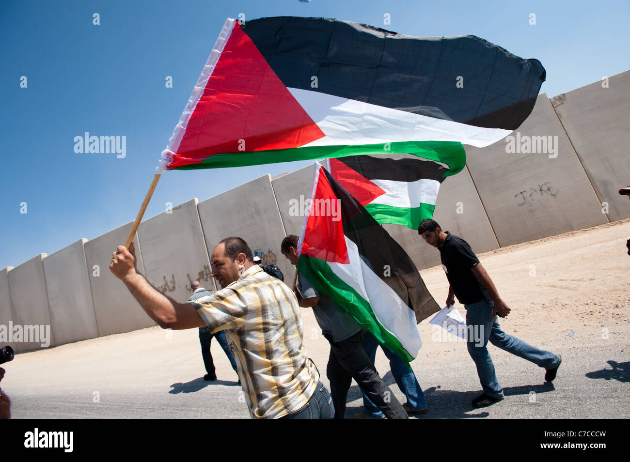 Palestinian protesters march in an anti-wall demonstration in Al-Walaja, West Bank. Stock Photo