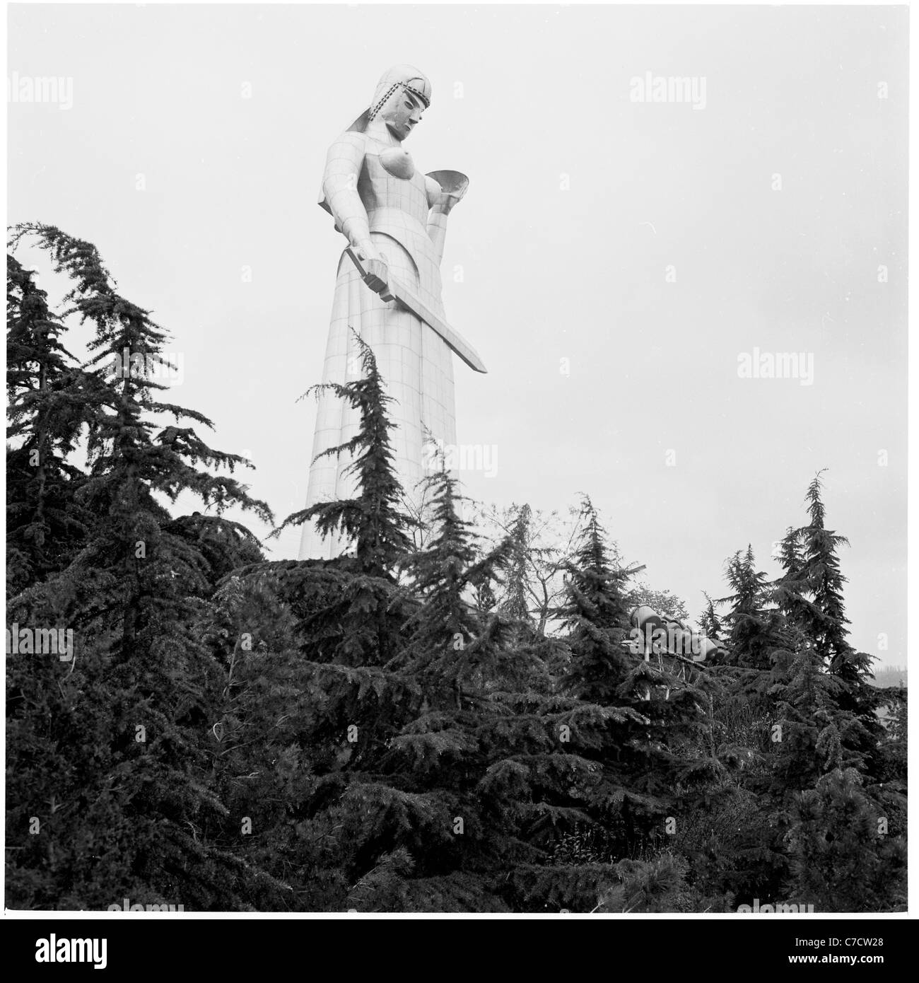 Historical picture, Russia, 1950s. A statue of a female soldier rises above the top of forest trees. Stock Photo