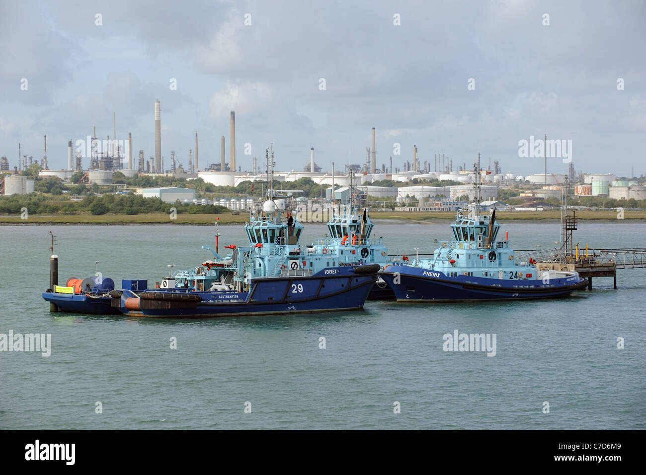 Ocean going tugs berthed on Southampton Water with a backdrop of Fawley Marine Terminal southern England UK Stock Photo