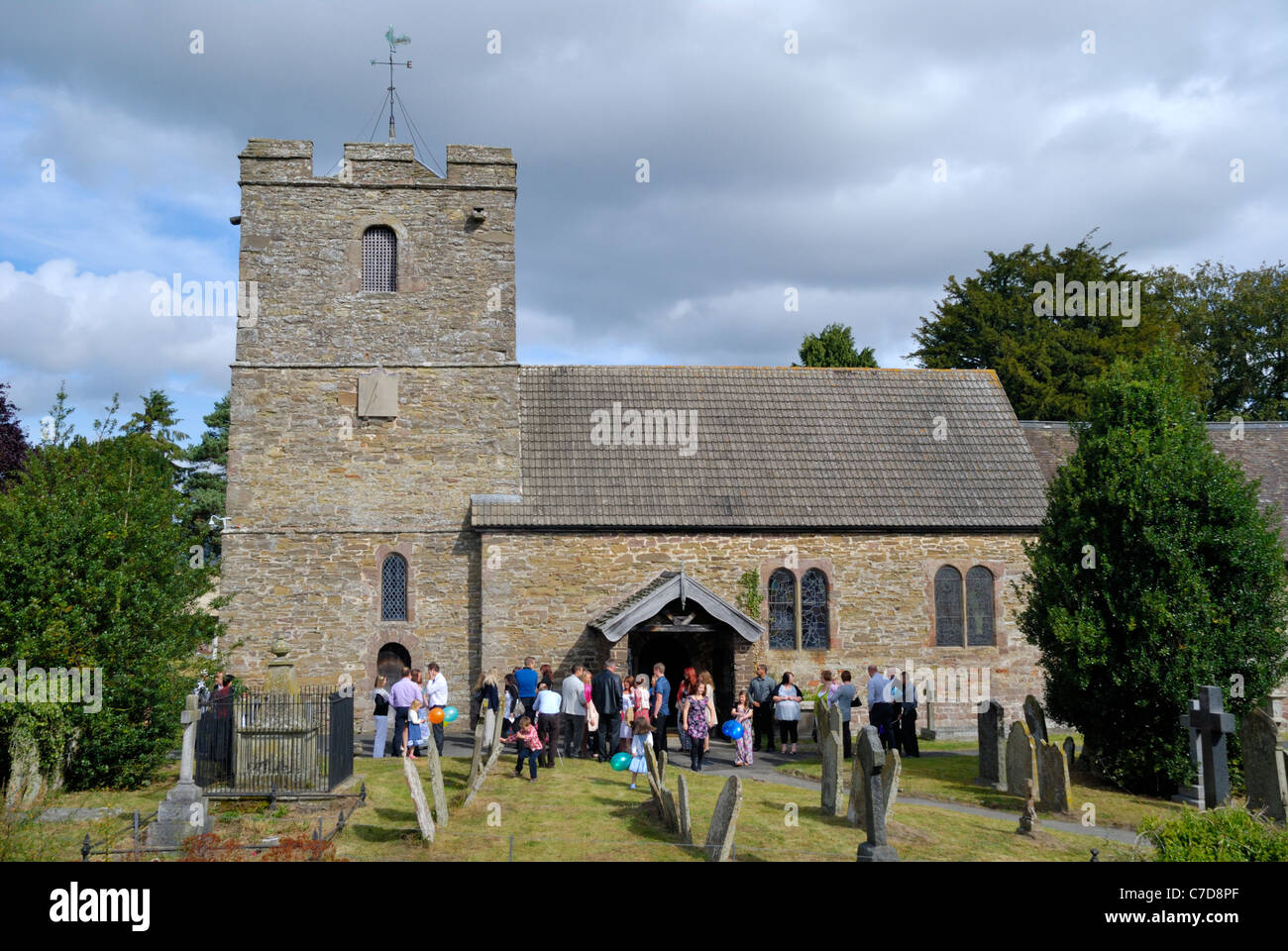Parishioners gather outside St John the Baptist church at Stokesay Castle, Shropshire, England Stock Photo