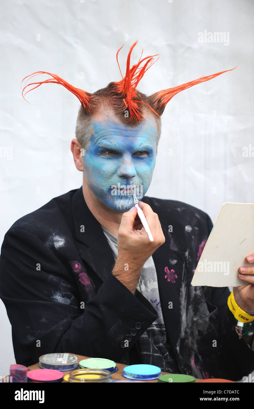 Man With Orange Spiked Punk Style Hair And Painted Blue Face At
