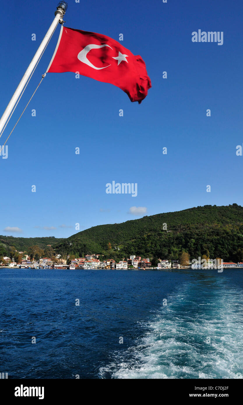 Turkish flag and the small fishing and tourist village of Anadolu Kavagi in background . The Bosporus Strait, near Istanbul. Stock Photo