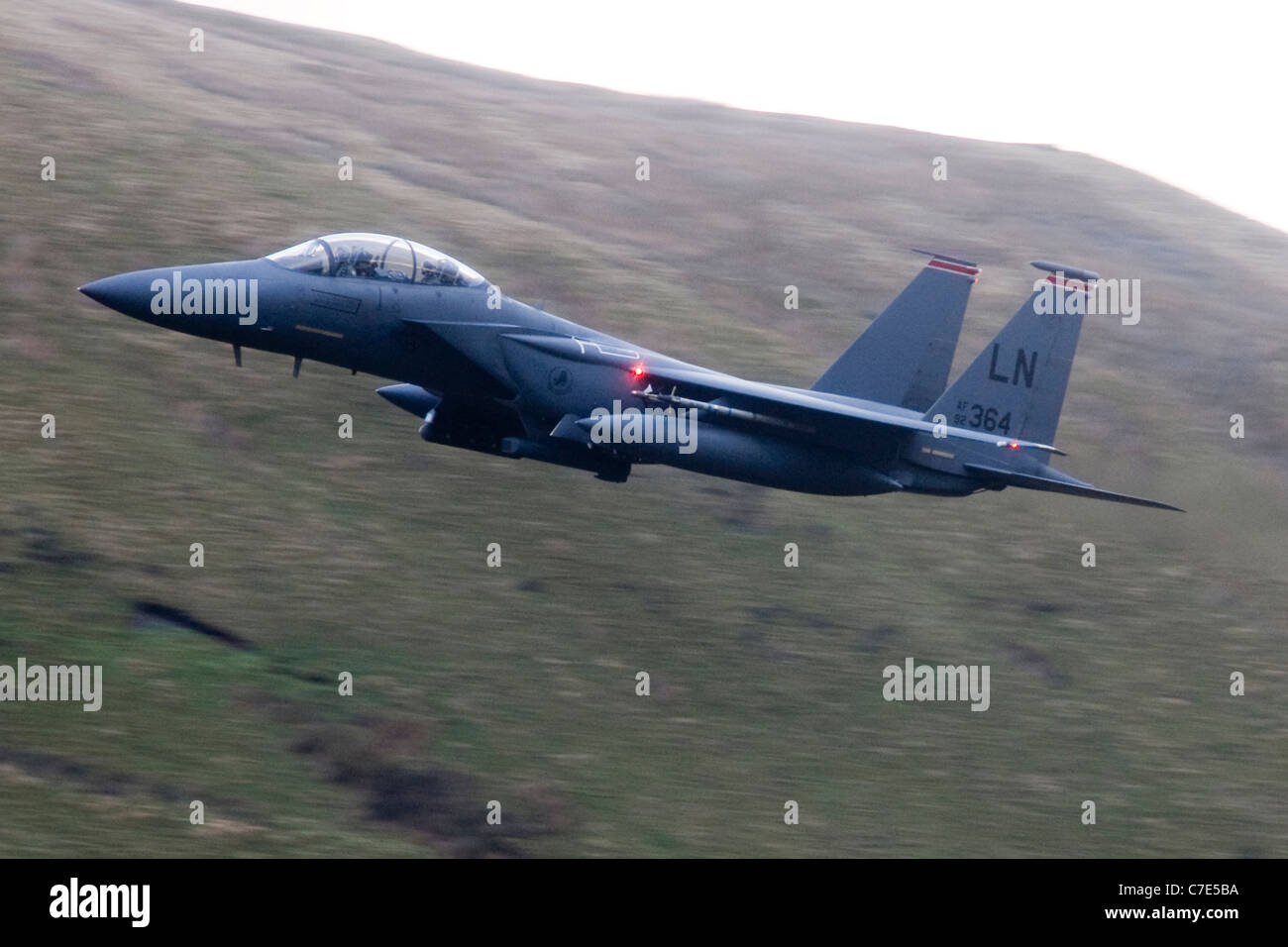 USAF F-15E Strike Eagle makes a turn mountains of Snowdonia in the background during a low flying flight Stock Photo