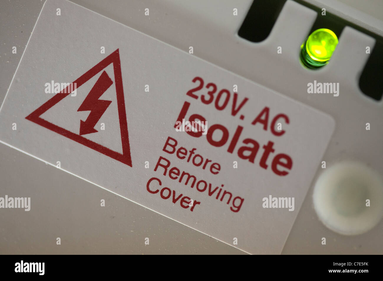 Isolate before removing Cover  Electrical Label and glowing Diode 230v AV Stock Photo