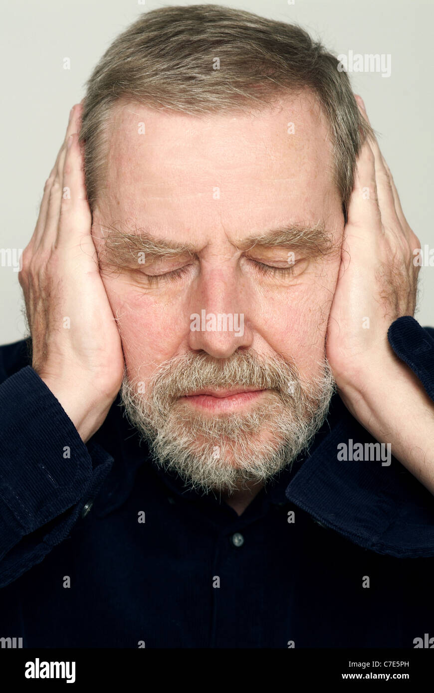 Man plugging his ears Stock Photo