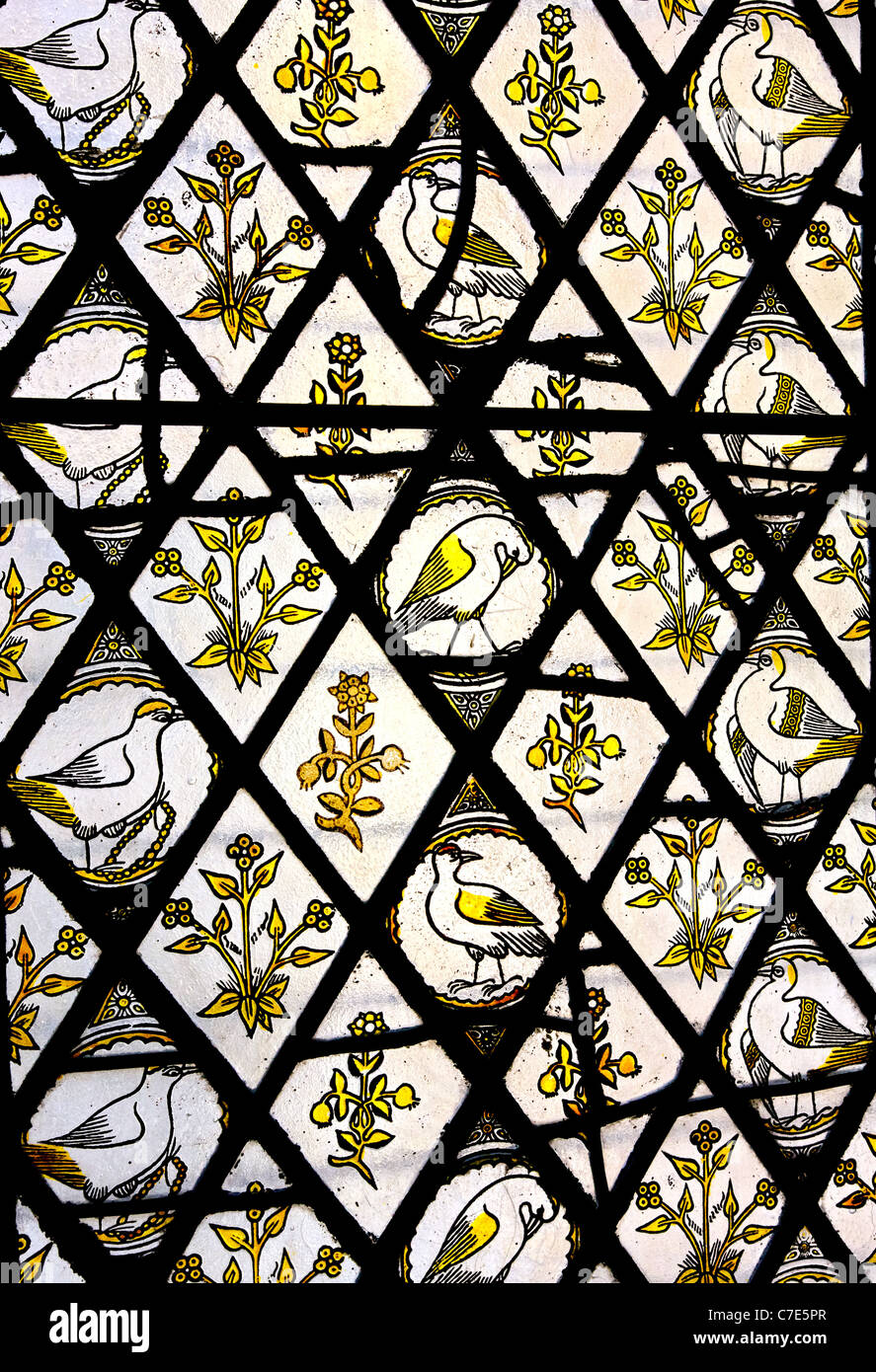 Arts and crafts movement stained glass window featuring yellow birds and flowers at Tyntesfield in Somerset Stock Photo
