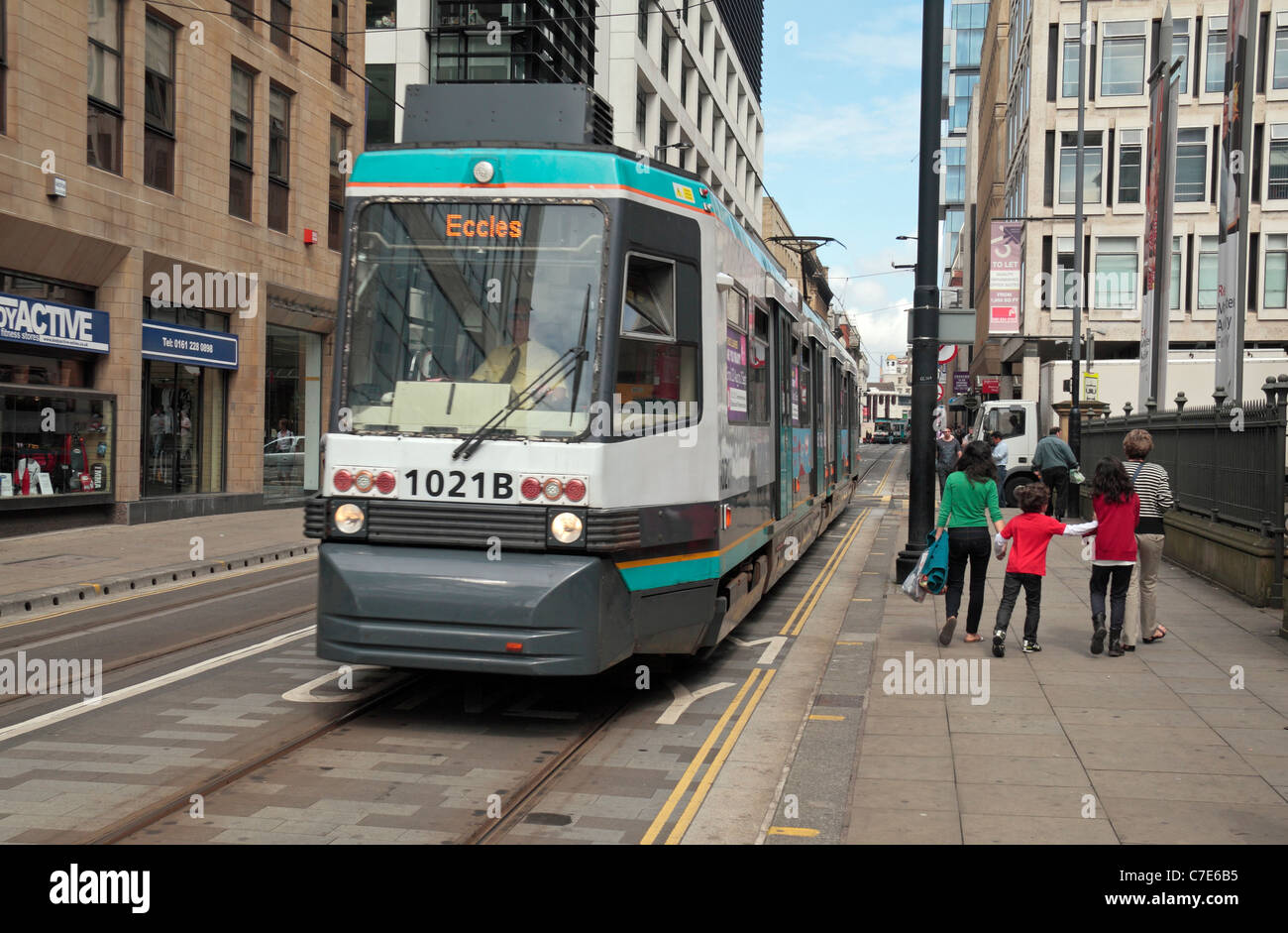 A Manchester Metrolink tram moving over a 'Tram Only' sign on the road in Manchester, UK.  (Slight movement blur on tram) Stock Photo