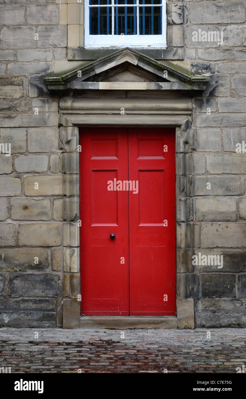 Red door and cobbles, detail from the 17th century Canongate Kirk in Edinburgh's Royal Mile. Stock Photo