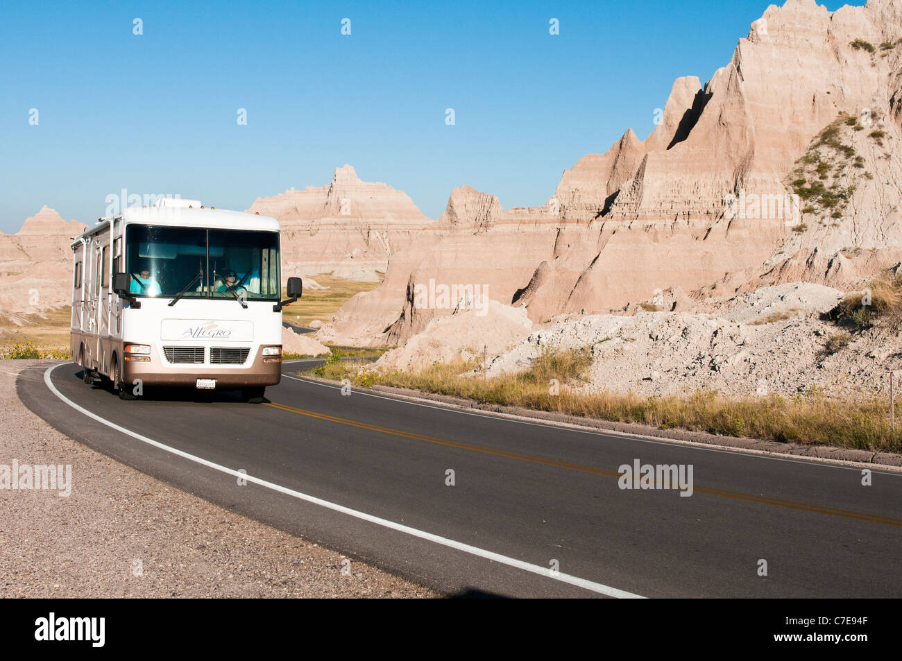 Tourists in a recreational vehicle drive through Badlands National Park