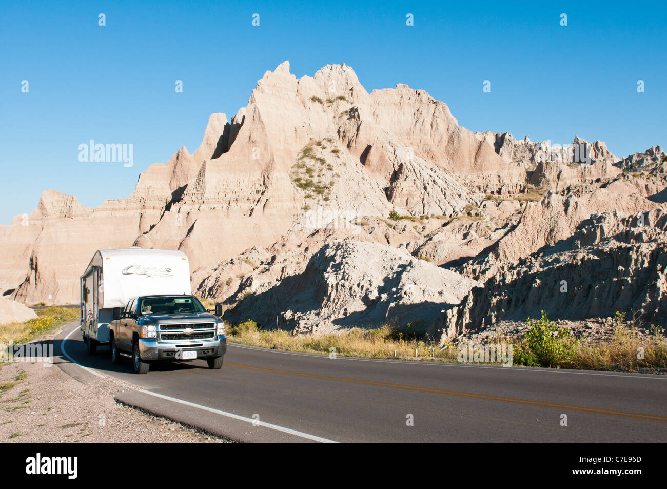 Tourists in a recreational vehicle drive through Badlands National Park