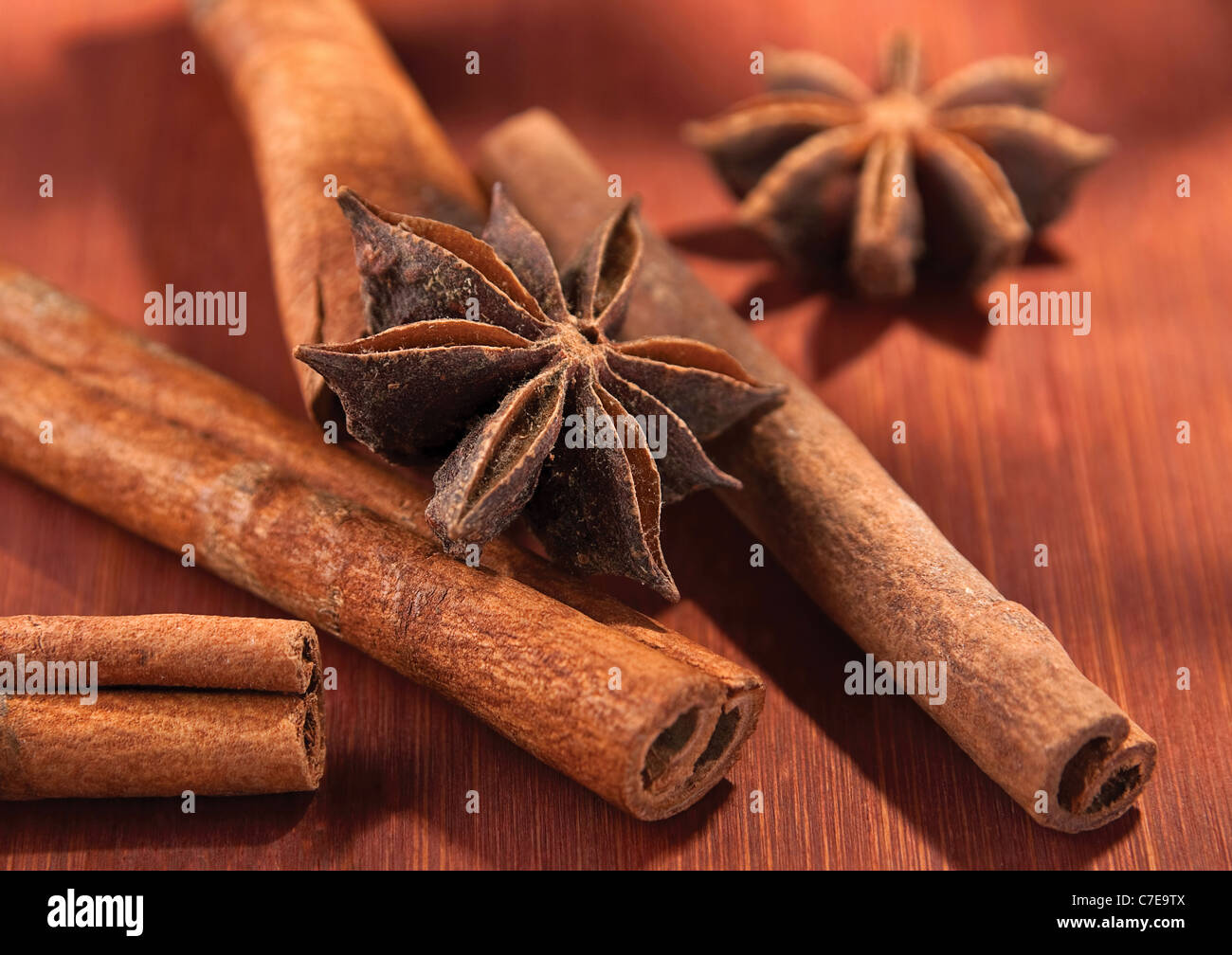 Stick of cinnamon with anise closeup on brown board Stock Photo