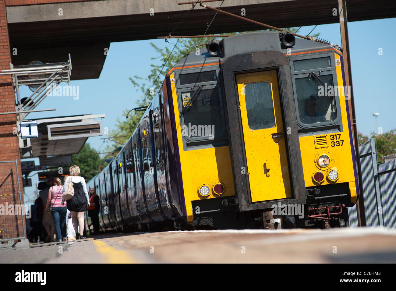 Passengers getting off of a train at a railway station in England Stock