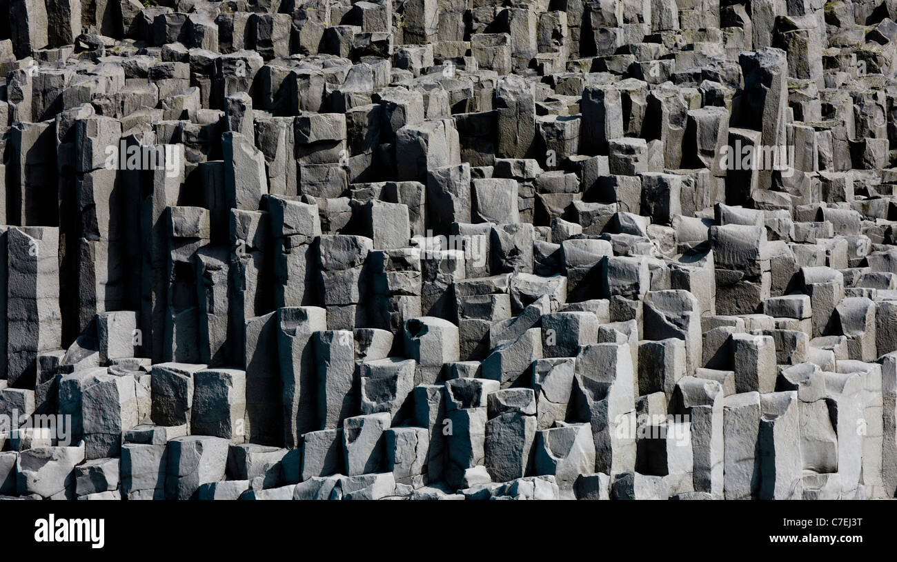 Tourists at the beach Reynisfjara, columnar basalt in the back - Stock Photo