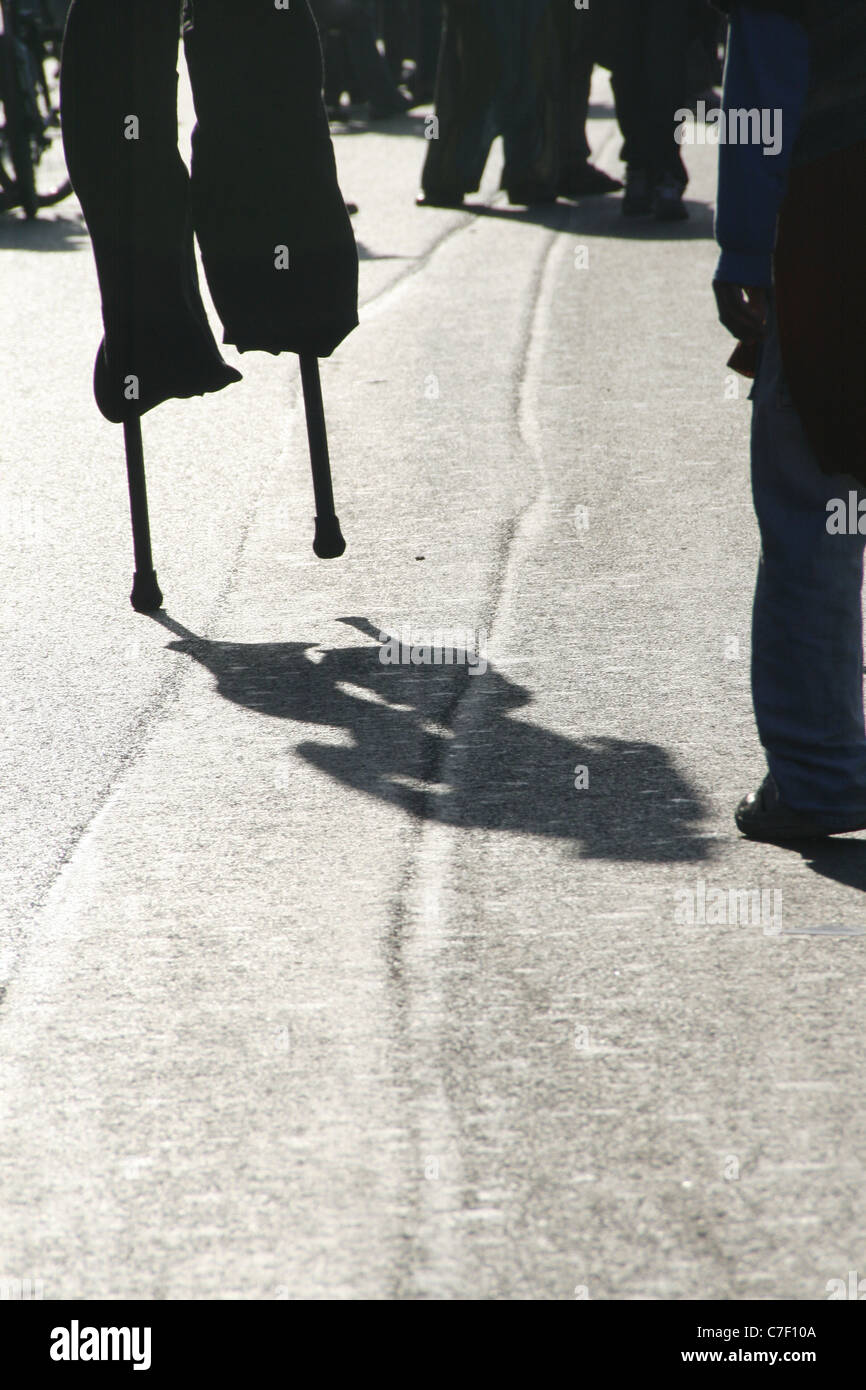 person man walking on stilts in street road in city town Stock Photo