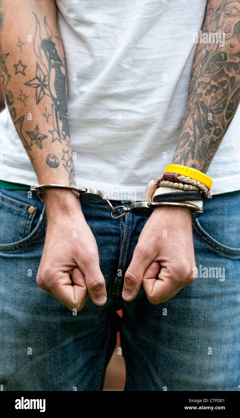 Handcuffed teenager with tattoos Stock Photo