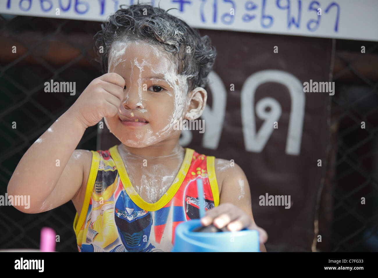 Thai kid eating during  song kran buddhist new year festical celebration in silom road, Bangkok, Thailand Stock Photo
