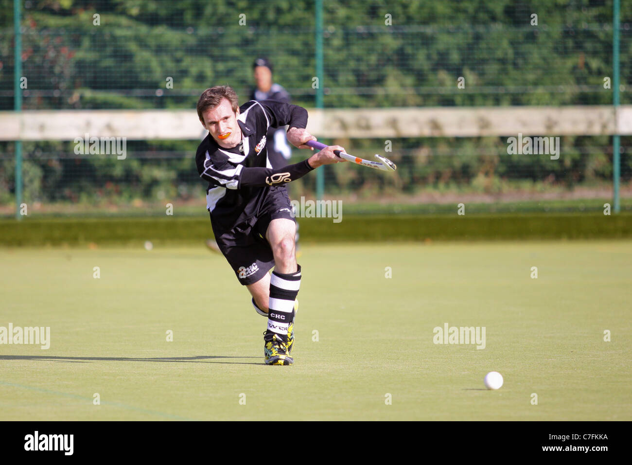 A male hockey player in action on an astro turf pitch Stock Photo