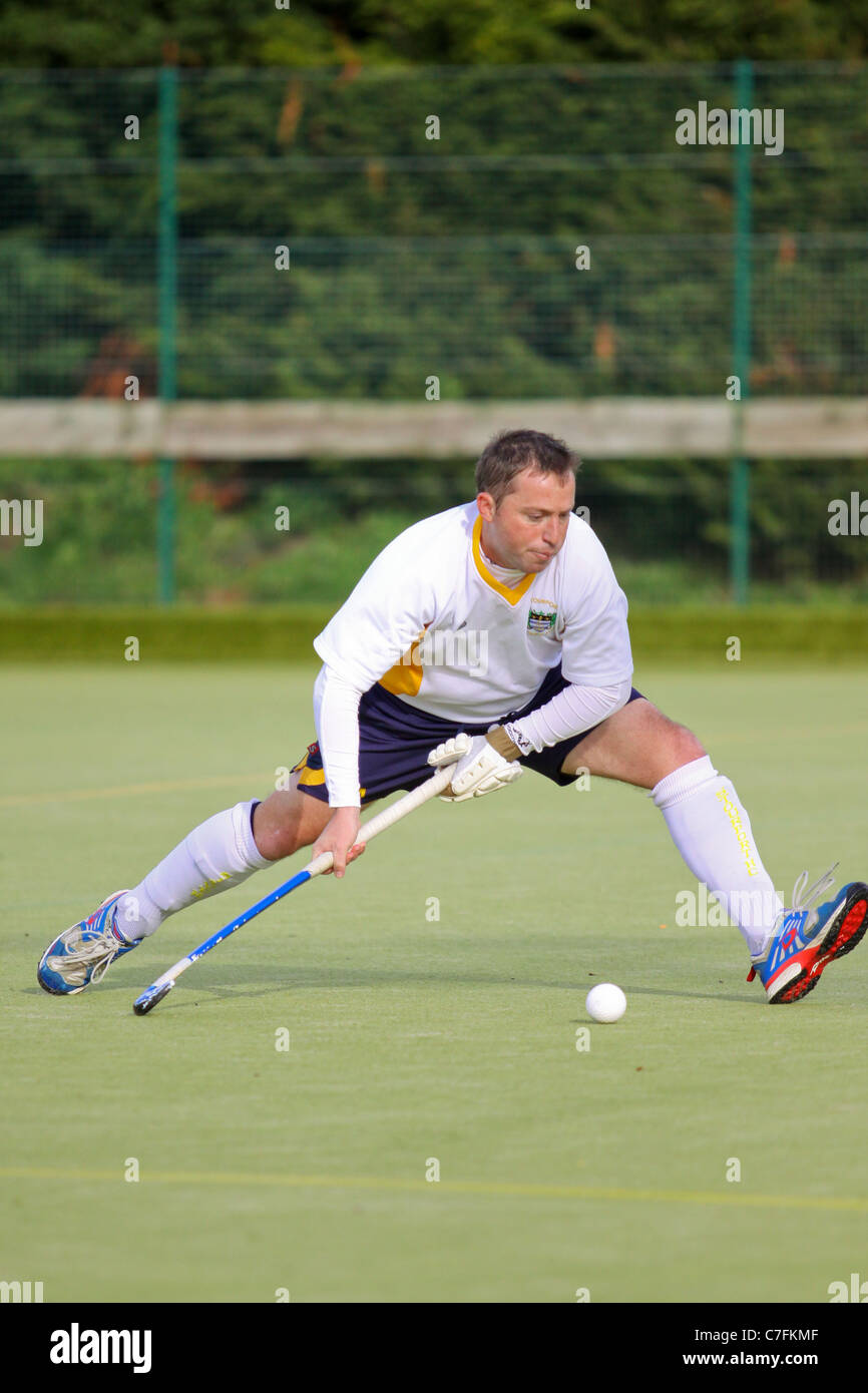 A male hockey player in action on an astro turf pitch Stock Photo